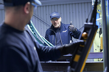 Two Leadec employees troubleshooting the conveyor system in an automotive factory.