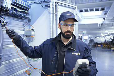 A Leadec employee analyzing faults and repairing installed electronics.